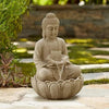 A table-top fountain featuring a statue of Lord Buddha surrounded by lotus flowers, with water gently flowing around or from the statue and the flowers.