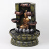 A resin table-top fountain featuring a statue of Lord Buddha, with water flowing around or from the statue.