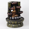 A resin table-top fountain featuring a statue of Lord Buddha, with water flowing around or from the statue.