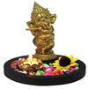 Handcrafted Ganesha gift set featuring a plastic idol, lotus-shaped tealight holder, stylish black tray, and decorative stones, perfect for altars."