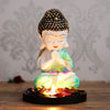 Serene polyresin statue of a young monk in deep contemplation, featuring soft green and white hues, with a natural wood base and tealight holder