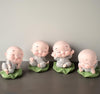 Set of four smiling little monk figurines made from resin, perfect for home decor or car dashboard embellishments, radiating tranquility and positivity